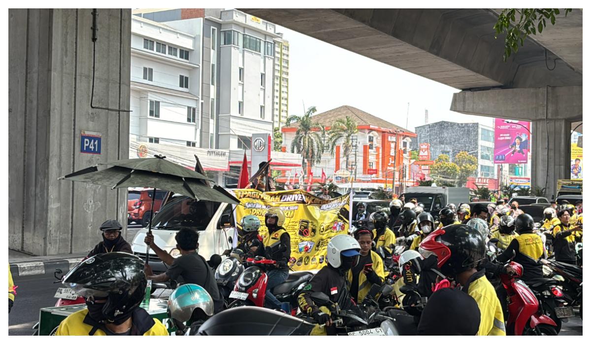 2026-10-20 - Massa dan sebuah mobil komando jenis pick-up Ratusan pengemudi ojek online Maxim berjaket kuning berunjuk rasa di depan Gedung DPRD Sulsel, Makassar