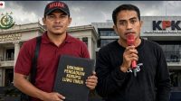 Ilustrasi pengaduan MUAK ke Kejaksaan Agung dan KPK Ilustrasi dua orang membawa dokumen pengaduan dugaan korupsi Luwu Timur di depan gedung Kejaksaan Agung dan KPK